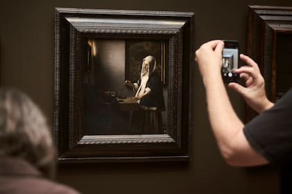 Un visitante fotografía "Woman Holding a Balance", de Vermeer, en la Galería Nacional de Arte de Washington. Varias obras atribuidas al pintor holandés están actualmente en estudio