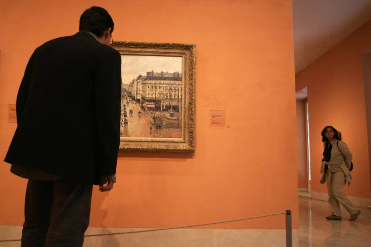 Un visitante observa el cuadro 'Rue Saint-Honoré por la tarde. Efecto de lluvia', de Camille Pisarro, en el museo Thyssen-Bornesmisza de Madrid