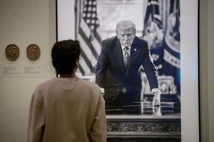 Un visitante se detiene a ver la fotografía del presidente Donald Trump en la exposición "Presidentes Estadounidenses" de la Galería Nacional de Retratos del Instituto Smithsoniano
