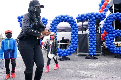 Un voluntario instala una exhibición de globos durante un mitin de votación para los candidatos demócratas al senado Jon Ossoff y Raphael Warnick en Hampton, Georgia, el 2 de enero de 2021