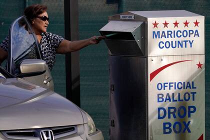 Un votante deposita su voto en un buzón electoral en el Centro de Elecciones y Tabulación del condado de Maricopa en Phoenix, el martes 1 de noviembre de 2022. (AP Foto/Matt York)