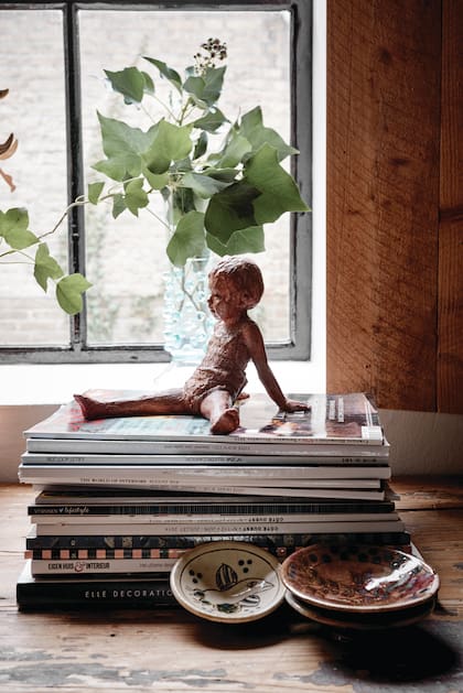 Un zoom al escritorio revela el gusto de la anfitriona por las miniaturas: la figura de loza que le compró a un artista en Francia y los platos de un anticuario de Amberes.