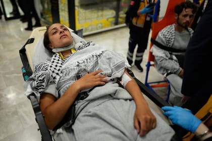 Una activista herida es trasladada en camilla a su llegada a Estambul