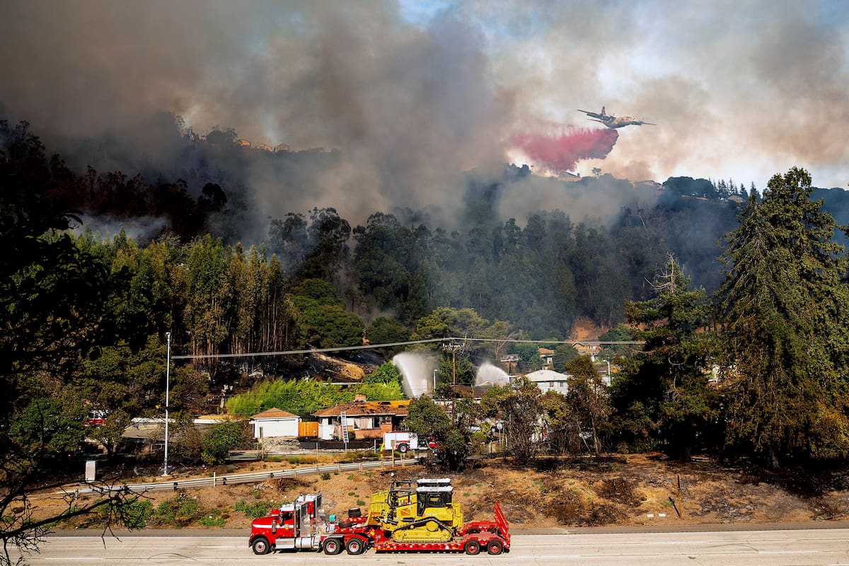 Una aeronave arroja retardante de fuego sobre un incendio que arde cerca de la carretera interestatal 580, el viernes 18 de octubre de 2024, en Oakland, California. (AP Foto/Noah Berger)
