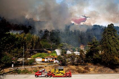 Una aeronave arroja retardante de fuego sobre un incendio que arde cerca de la carretera interestatal 580, el viernes 18 de octubre de 2024, en Oakland, California. (AP Foto/Noah Berger)