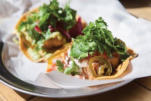 Una badeja con dos nachos listos para servir