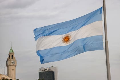 Una bandera argentina ondea sobre la Plaza de Mayo y a metros de Casa Rosada