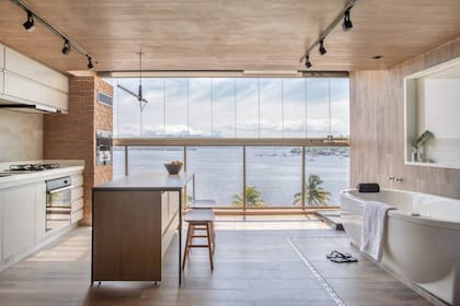 Una bañera 'freestanding' enfrentada a una cocina abierta