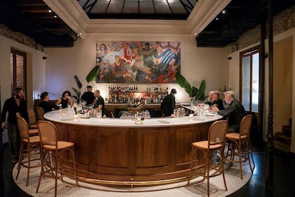 Una barra en mármol de carrara y forma de herradura, enmarcada por una obra del artista Martín Kazanietz, recibe y ordena el espacio.