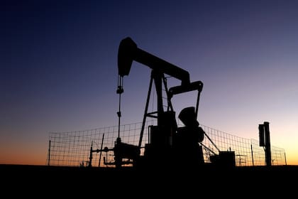 Una bomba opera en un pozo petrolero en un prado al amanecer del lunes 30 de septiembre de 2024 cerca de Hays, Kansas, Estados Unidos. (AP Foto/Charlie Riedel)