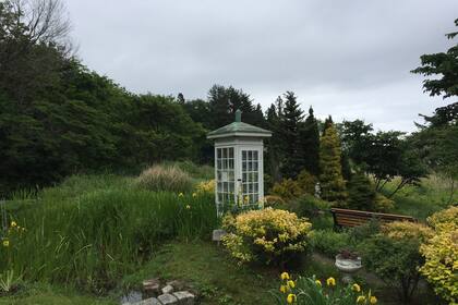 Una cabina telefónica en un jardín de la región japonesa de Otsuchi, lugar de peregrinaje para “hablar” con los seres queridos que murieron