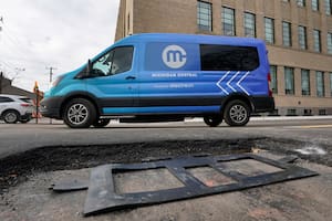 Una camioneta eléctrica pasa el miércoles 29 de noviembre de 2023 frente a una bobina de cobre de carga inalámbrica que será instalada en una calle de Detroit para que los vehículos eléctricos puedan cargar sus baterías al pasar por ahí, quedarse parados o estacionados. (AP Foto/Paul Sancya)