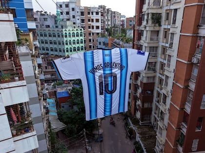 Una camiseta gigante de la selección nacional de fútbol de Argentina, dedicada a Lionel Messi, cuelga entre dos edificios de apartamentos en el área de Ibrahimpur de Dhaka
