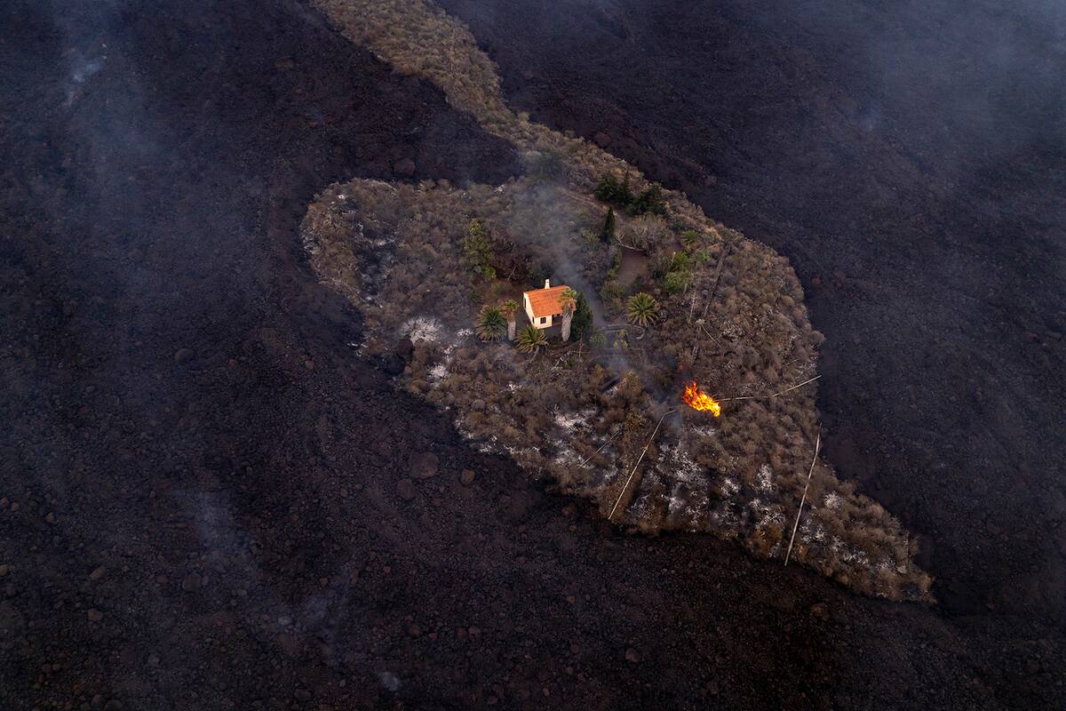 Una casa permanece intacta mientras la lava fluye después de que un volcán entró en erupción cerca de Las Manchas en la isla de La Palma en Canarias