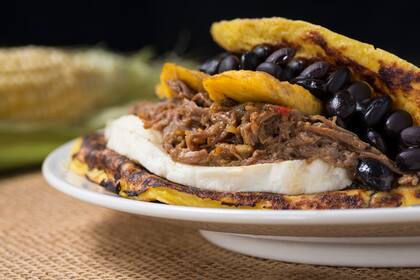 Una cachapa es una especie de crêpe salada de masa de maíz con distintos rellenos. En la foto se ve la de porotos, plátano frito, carne desmenuzada y queso blanco, conocida como "cachapa de pabellón".