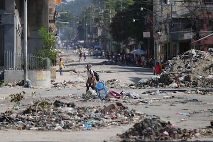Una chica cruza una calle llena de basura en el centro de Puerto Príncipe, Haití, el 20 de enero de 2026