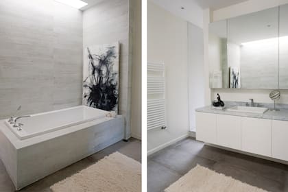 Una claraboya lleva luz natural a la bañadera con revestimiento de porcelanato cementicio. Espejo con botiquín embutido.Acrílico de Rodrigo García Berro.