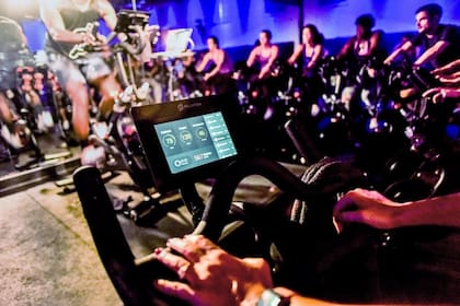Una clase en el salón de exhibición de Peloton en Nueva York en 2016. La tableta de la bicicleta tiene una cámara y un micrófono incorporados, que permite a los usuarios verse y escucharse unos a otros, si así lo desean
