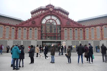 Una cola de votantes fuera del mercado de Sant Antoni, que se utiliza como colegio electoral en Barcelona