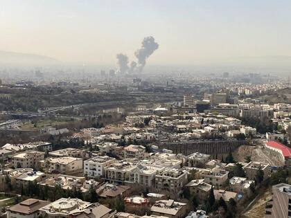 Una columna de humo emerge del centro de Teherán tras un ataque israelí este sábado