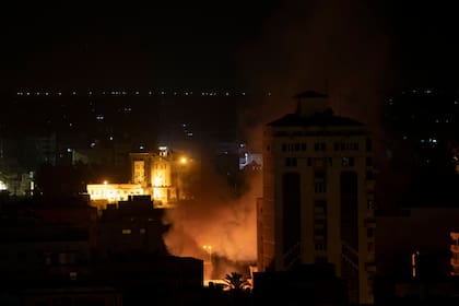 Una columna de humo marca el lugar donde impactó un misil israelí, en la Ciudad de Gaza, el 14 de mayo de 2021. (AP Foto/Khalil Hamra)