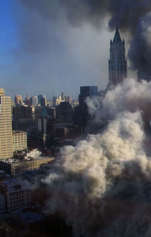 Una columna de humo se eleva tras el derrumbe de los edificios del World Trade Center, vista desde el oeste y con el edificio Woolworth enmarcado a la distancia, en Manhattan, el 11 de septiembre de 2001
