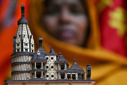 Una comerciante muestra una maqueta del nuevo templo de Rama antes de la ceremonia de inauguración en Ayodhya.
