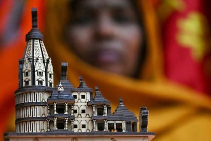 Una comerciante muestra una maqueta del nuevo templo de Rama antes de la ceremonia de inauguración en Ayodhya.