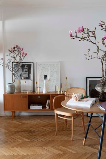 Una cómoda vintage sostiene los candelabros de bronce que Irina Khatsernova mandó a hacer en Argentina. Coronando la puesta, las flores de Magnolia foscata.