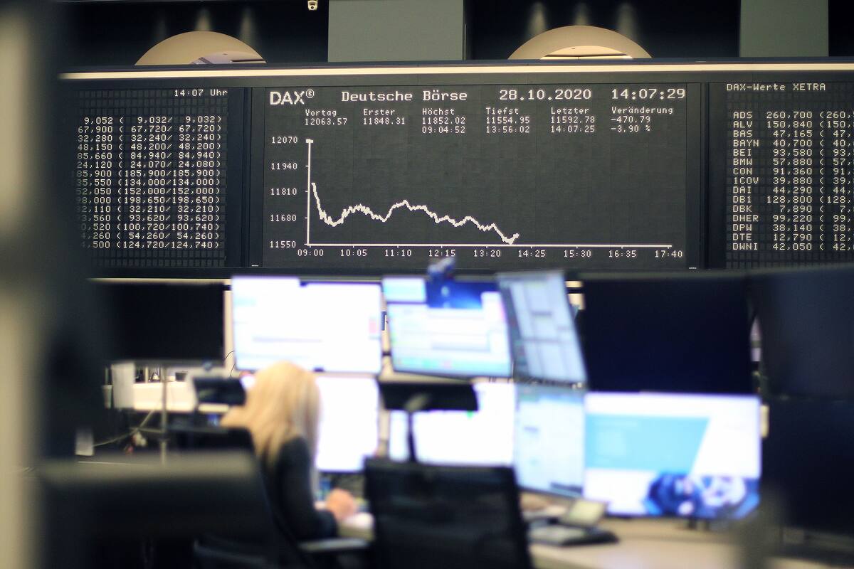 Una corredora se sienta debajo de la pantalla que muestra la evolución del índice bursátil alemán DAX en la bolsa de valores de Frankfurt, Alemania, el 28 de octubre de 2019, en medio de la pandemia de coronavirus