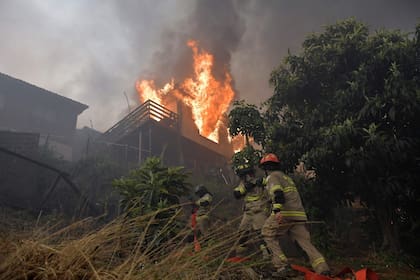 Una de las casas en llamas.