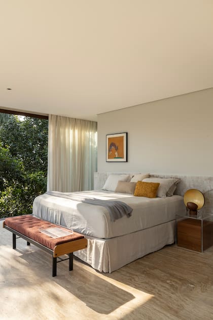Una de las habitaciones principales: textiles en neutros con aires minimalistas conviven con la frondosa selva.
