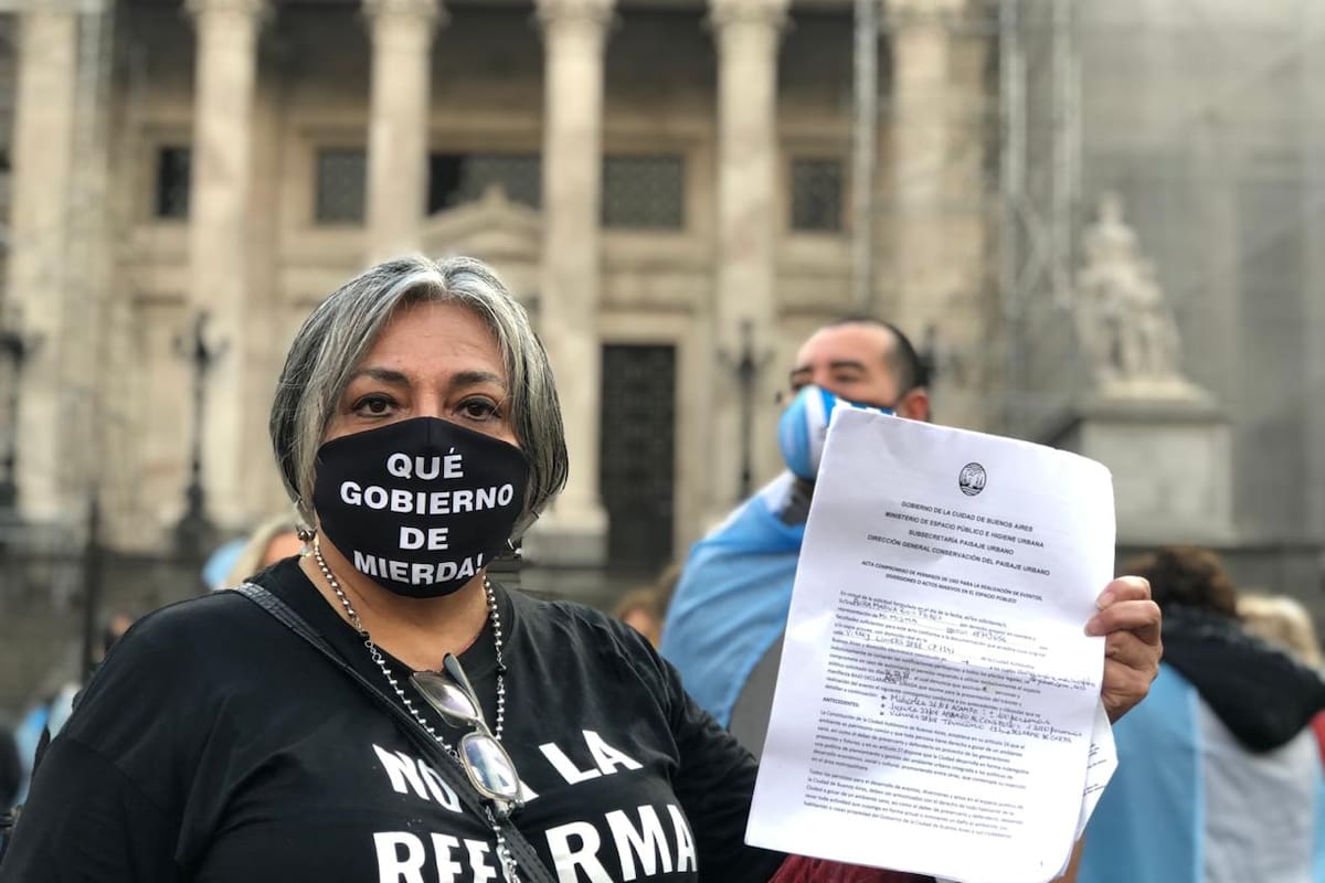 Una de las manifestantes exhibe la autorización de la Ciudad para armar la carpa, pero después no le dejaron instalarla