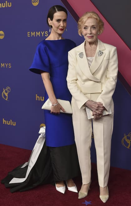 Una de las parejas que desplegó su buena onda en la previa a la ceremonia de entrega de premios fue la compuesta por Sarah Paulson y Holland Taylor. Nominada por su breve papel como invitada en la serie Mr. and Mrs. Smith, Paulson eligió un vestido de satén de Prada azul, negro de falda asimétrica y cola. Taylor, en cambió, se decantó por un sobrio traje color manteca y un top a tono