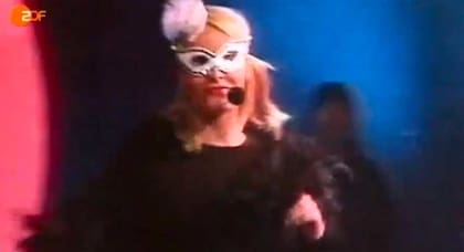 Una de las pocas imágenes de Mette-Marit, princesa de Noruega, con antifaz y boa de plumas, durante su presentación en el reality show "La Casa de Placer".