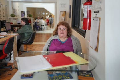 Una de las socias de Casaclub Baires da la bienvenida en la recepción. De fondo se ve un joven trabajando en el área de membresías y más atrás, el bar.