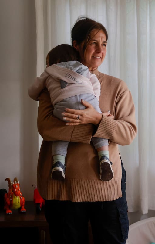 Una de las voluntarias carga en sus brazos a uno los primeros 10 niños que llegaron al hogar