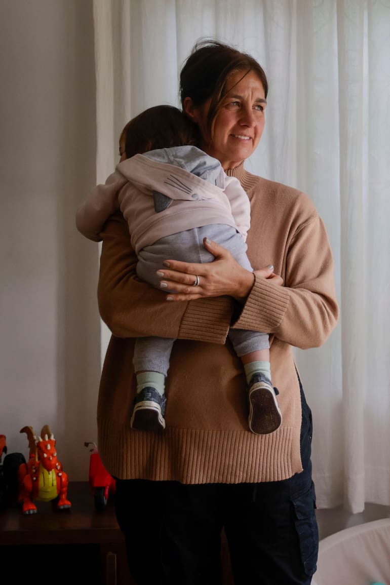 Una de las voluntarias carga en sus brazos a uno los primeros 10 niños que llegaron al hogar
