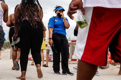 Una embajadora de buena voluntad monitorea a los bañistas en Miami Beach, Florida, 6 de marzo de 2021