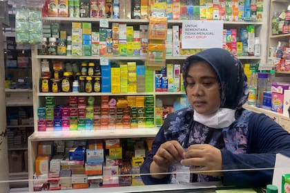 Una empleada espera clientes en una farmacia en Yakarta, Indonesia, el martes 1 de noviembre de 2022. (AP Foto/Tatan Syuflana)
