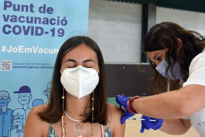Una enfermera administra la primera dosis de la vacuna Pfizer-BioNTech COVID-19 a una mujer en el Centro de Vacunación de Calafell, España.