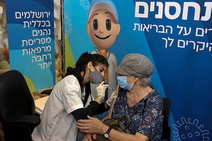 Una enfermera aplica una tercera dosis de la vacuna Pfizer-BioNtech en un complejo de cines de Jerusalén