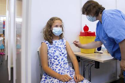 Una enfermera inyecta contra el Covid-19 a Gloria Raudjarv, de 13 años, en un centro deportivo en Tartu, Estonia, el 29 de julio de 2021. (AP Foto/Raul Mee)