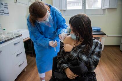Una enfermera le aplica una inyección de la vacuna Pfizer contra Covid-19 a una joven en Montevideo, Uruguay