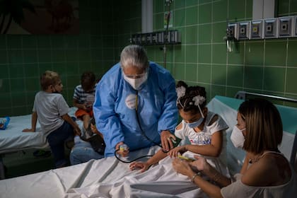Una enfermera le toma la presión arterial a una niña después de administrarle una dosis de la vacuna Soberana-02 de fabricación cubana contra el COVID-19 en La Habana, Cuba, el martes 24 de agosto de 2021. (AP Foto/Ramon Espinosa)