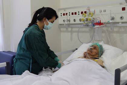Una enfermera monitorea a Ayse Karatay en el Hospital Municipal de Eskisehir, Turquía, el sábado 4 de septiembre de 2021. Karatay, una mujer turca de 116 años ha sobrevivido al COVID-19, dijo su hijo el sábado, lo que la convierte en una de las personas de más edad que vence la enfermedad. (IHA via AP)