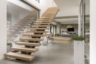 Una escalera sin barandas ni paredes que permite la visión de los ambientes a través de ella