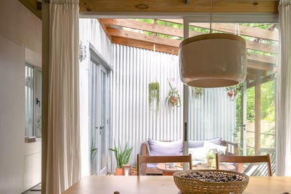 Una escalera sube al deck de acceso, equipado con muebles de madera dura y resistente a la intemperie.