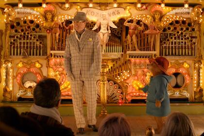 Una escena del film donde el oso Paddington comparte con Hugh Grant en la feria de la ciudad