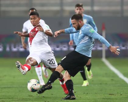Una escena del último enfrentamiento entre Uruguay y Perú: Nahitan Nández impacta la pelota ante la marca de Edison Flores